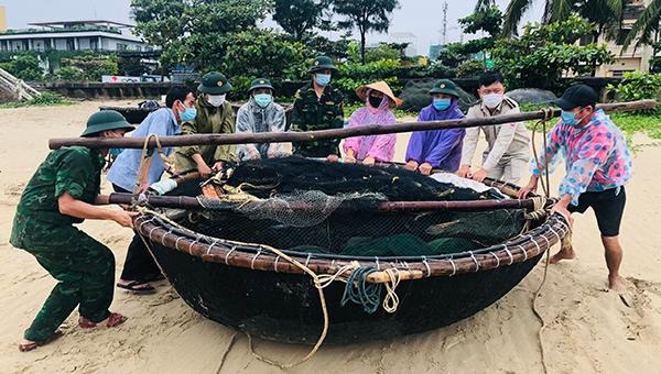 Lực lượng Bộ đội Biên phòng cùng dân quân tự vệ và người dân TP Đà Nẵng đưa tàu thuyền lên bờ để phòng chống bão số 5.