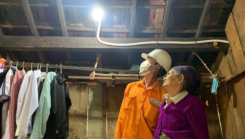 Nhân viên điện lực thay bóng đèn tiết kiệm năng lượng miễn phí cho hộ nghèo ở huyện Sơn Hà (Quảng Ngãi). 