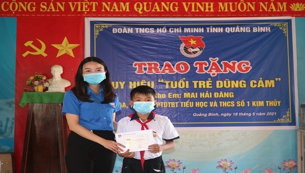 Phó Bí thư Tỉnh đoàn Quảng Bình Lê Thị Ngọc Hà trao Huy hiệu “Tuổi trẻ dũng cảm” cho em Đăng.