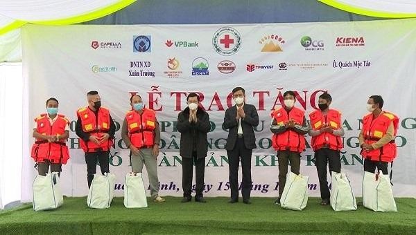 Nguyên Chủ tịch nước Trương Tấn Sang và ông Trần Thắng, Chủ tịch UBND tỉnh Quảng Bình cùng nhà tài trợ trao tặng áo phao cho ngư dân xã Cảnh Dương, huyện Quảng Trạch.