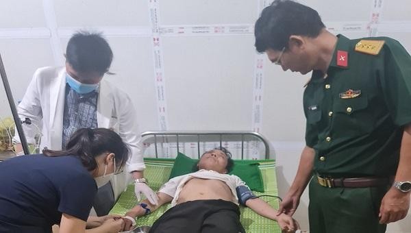 Lãnh đạo Ban CHQS huyện Tuyên Hóa cùng đội ngũ y tế Bệnh viện chăm sóc sức khỏe cho anh Minh.