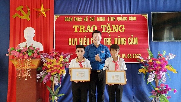 Đại diện Tỉnh đoàn Quảng Bình trao Huy hiệu “Tuổi trẻ dũng cảm” cho Mai Anh Vũ và Trần Ngọc Duy.