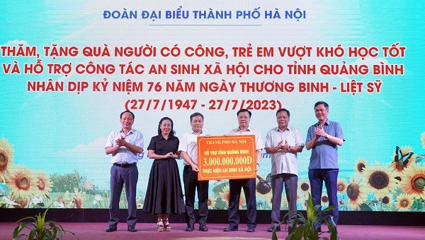 Bí thư Thành ủy TP. Hà Nội Đinh Tiến Dũng trao biển tượng trưng hỗ trợ an sinh 3 tỷ đồng cho tỉnh Quảng Bình.