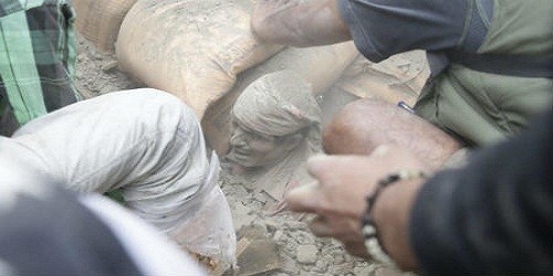 Một người đàn ông bị chôn vùi trong đống đổ nát được giải cứu ở Nepal.  Ảnh: AFP 