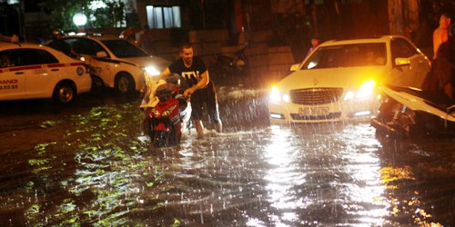 Người dân ở Hà Nội lại phải bì bõm trong nước ngập sâu sau cơn mưa chiều tối ngày 26/8.