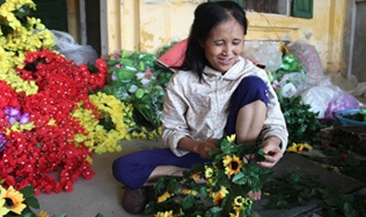 Chị Phạm Thị Lê đang ghép lá cho cành hoa lụa.