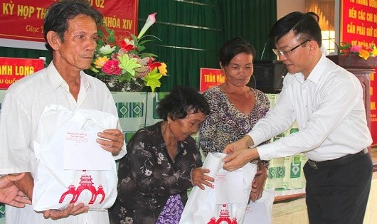 Bộ trưởng Lê Thành Long trao quà cho các gia đình có hoàn cảnh khó khăn.