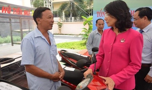 Phó Chủ tịch UBND TP HCM Nguyễn Thị Thu trao đổi với các hộ dân được nhận phương tiện làm ăn.