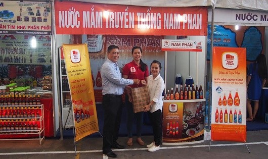 Nhà báo Hà Quang Ngọc, Báo Pháp luật Việt Nam tặng quà doanh nghiệp sản xuất và kinh doanh  nước mắm truyền thống tham gia triển lãm. Ảnh: Phi Hùng.