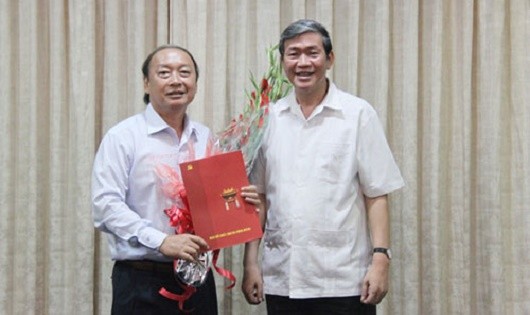 Đồng chí Đinh Thế Huynh (phải) trao quyết định và tặng hoa chúc mừng đồng chí Võ Văn Phuông
