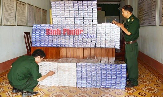 Bộ đội Biên phòng tỉnh Bình Phước kiểm tra thuốc lá lậu bị bắt giữ khi vận chuyển trái phép qua biên giới. 
Ảnh: Báo Bình Phước