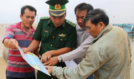 Trung úy, Trạm trưởng Phạm Văn Huân xác định vùng ngư trường trên bản đồ cho ngư dân trong tổ tàu thuyền an toàn.