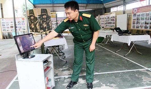 Đại úy QNCN Nguyễn Xuân Vệ bên sáng kiến “Thiết bị báo điểm chạm trong kiểm tra bắn đạn thật”.