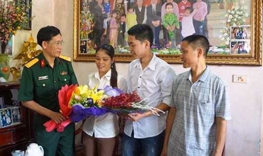 Cán bộ Học viện Kỹ thuật Quân sự tặng quà chúc mừng thí sinh Lê Thanh Lâm - trúng tuyển thủ khoa vào Học viện năm 2017 