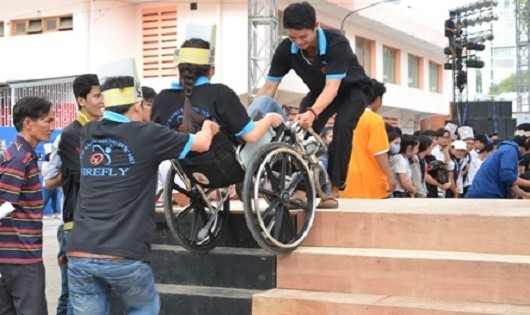 Người khuyết tật cần người trợ giúp khi vượt qua các bậc tam cấp.