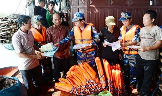 Cán bộ, nhân viên tàu CSB-8004 tuyên truyền pháp luật và tặng áo phao cho ngư dân. 