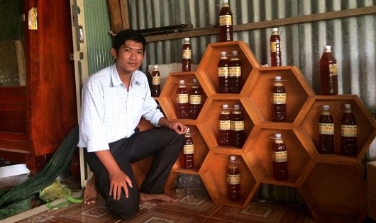 Anh Thành Long bên sản phẩm Mật ong  Hương Tràm do cơ sở của anh sản xuất.