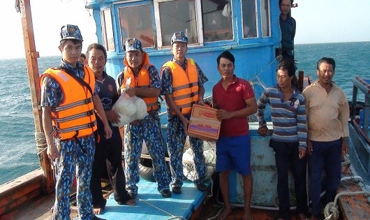 Cán bộ, chiến sĩ tàu CSB 9001 tặng lương thực, thực phẩm cho các ngư dân tàu KH 99036TS sau khi cứu nạn tàu cá ngày 12/3/2018