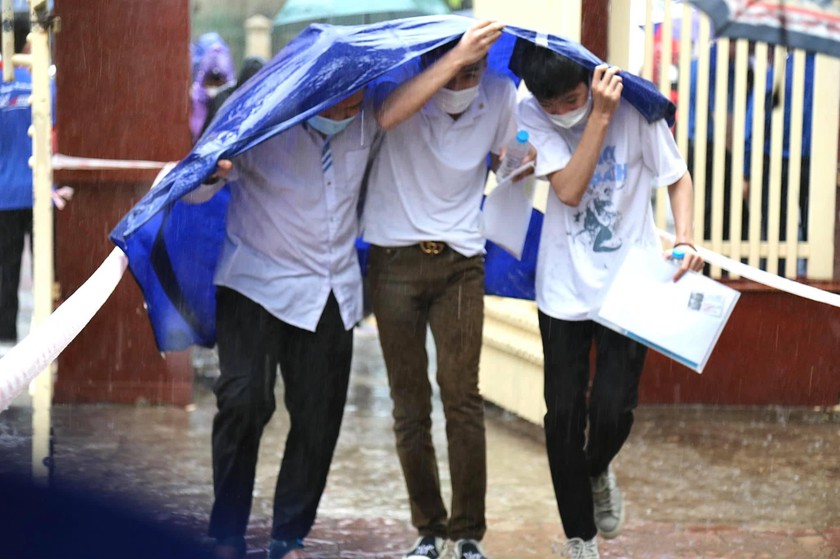 Các thi sinh đội mưa đến điểm thi.
