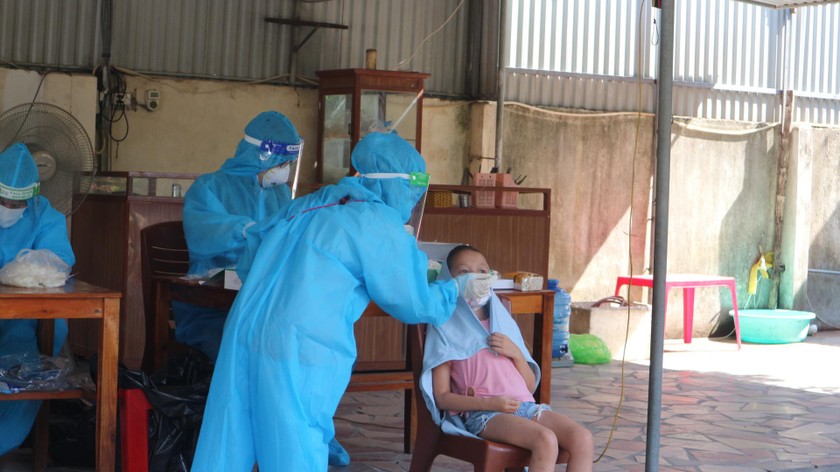 Lực lượng y tế lấy mẫu xét nghiệm test nhanh kháng nguyên theo hình thức mẫu gộp hộ gia đình tại xóm 3, xã Nghi Phú.