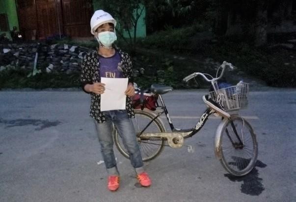 Em Lương Văn Khôi bên chiếc xe đạp được chủ trọ tặng làm phương tiện để về quê