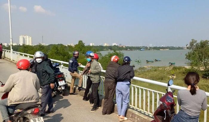 Người dân đứng trên cầu Bến Thủy dõi theo công tác tìm kiếm, vớt thi thể anh L. lên bờ