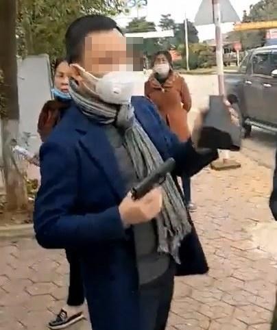 Hình ảnh ông Hồ Văn Nam cầm súng rại một văn phòng công chứng ở thị trấn Nghĩa Đàn.