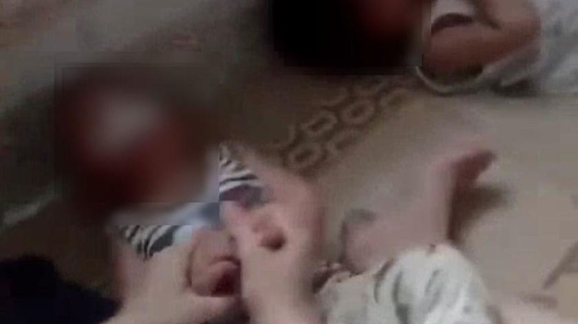 Bé trai 11 tháng tuổi ở Thái Bình nghi bị cô gái ở lớp mầm non nhét giẻ vào miệng, giữ chặt tay chân. Ảnh cắt từ clip.