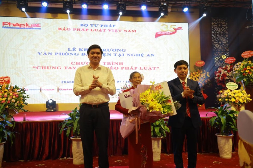 Mẹ Việt Nam anh hùng Nguyễn Thị Lan (ở giữa) nhận hoa và sổ tiết kiệm do Báo Pháp luật Việt Nam trao tặng.