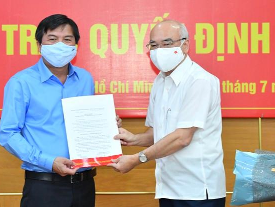 Ông Tăng Hữu Phong (bên trái) nhận quyết định từ Trưởng Ban Tuyên Giáo Thành ủy TP HCM Phan Nguyễn Như Khuê. Ảnh: VIỆT DŨNG