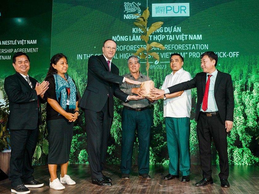 Ông Mark Schneider, Giám đốc điều hành Tập đoàn Nestlé (thứ 3 từ trái sang) trao cây đến người nông dân, khởi động dự án Nông lâm kết hợp tại Việt Nam.