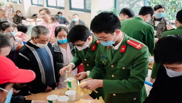 Các chiến sĩ Công an thị xã Hương Trà phát cháo cho các bệnh nhân.