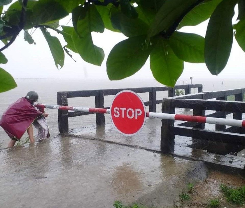 Lập barie đảm bảo an toàn cho người và phương tiện không lưu thông trong thời điểm nước chảy xiết do mưa lũ trái mùa tại Phong Điền (tỉnh Thừa Thiên Huế).