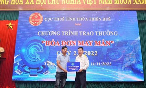 Đại diện Cục Thuế tỉnh Thừa Thiên Huế trao thưởng cho khách hàng có hóa đơn may mắn.