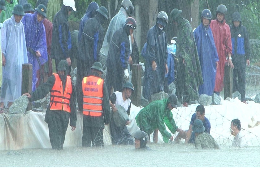 Bộ đội, dân quân ngâm mình giữa mưa lũ đắp đê chống sạt lở.