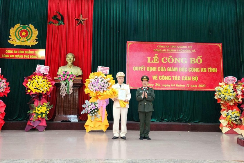 Đại tá Lê Phương Nam trao quyết định và tặng hoa chúc mừng Trung tá Ngô Nhật Tân.