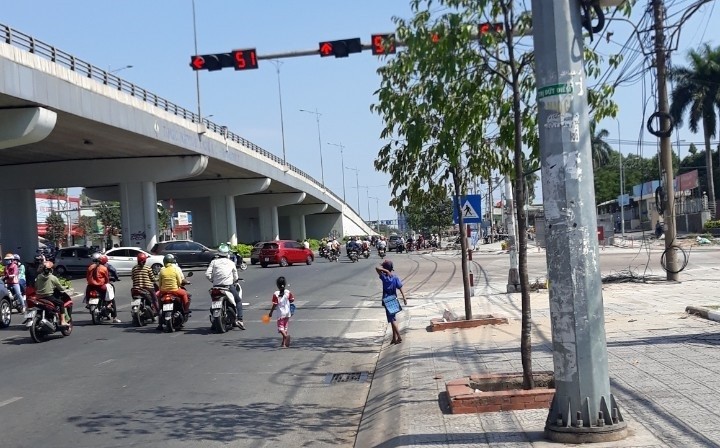 Những trẻ em chạy xuống đường ăn xin giữa dòng xe cộ tại ngã tư Amata 