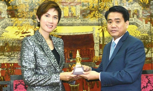 Chủ tịch UBND TP Nguyễn Đức Chung trao quà lưu niệm cho Quốc vụ khanh cấp cao Singapore – bà Josephine Teo.