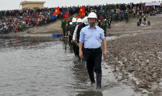 Bộ trưởng Trần Hồng Hà cùng người dân ra bãi biển trồng cây giúp giảm nhẹ thiên tai. Ảnh: TN&MT.