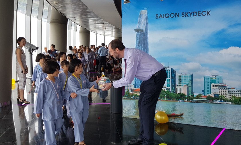 Đại diện Ban quản lý đài quan sát Sài Gòn Skydeck chào đón và tặng quà cho các em thiếu nhi.