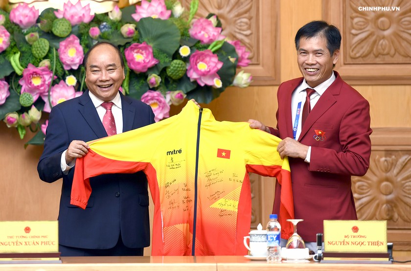 Thủ tướng nhận quà là chiếc áo đồng phục của Đoàn thể thao Việt Nam có chữ ký của các vận động viên đoạt huy chương tại ASIAD