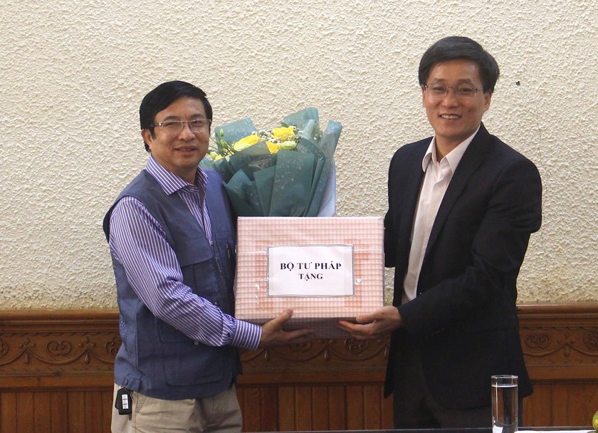 Thứ trưởng Nguyễn Khánh Ngọc (phải) trao Quyết định nghỉ hưu cho ông Nguyễn Văn Toàn, Phó Cục trưởng Cục Hộ tịch Quốc tịch Chứng thực (trái)