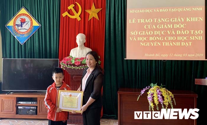 Bà Vũ Liên Oanh - Giám đốc Sở GD&ĐT Quảng Ninh trao học bổng 5 triệu đồng và giấy khen của Sở cho em Nguyễn Thành Đạt.