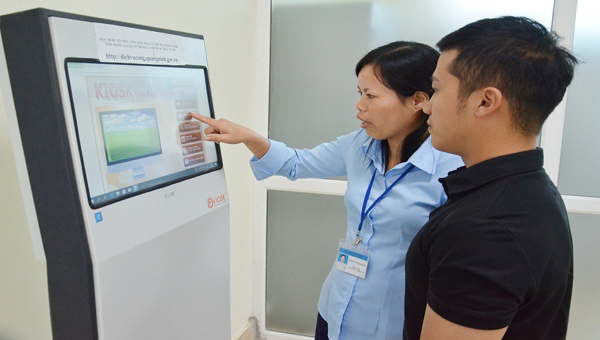 Cán bộ Trung tâm hành chính công tỉnh Quảng Ninh hướng dẫn người dân sử dụng dịch vụ công trực tuyến