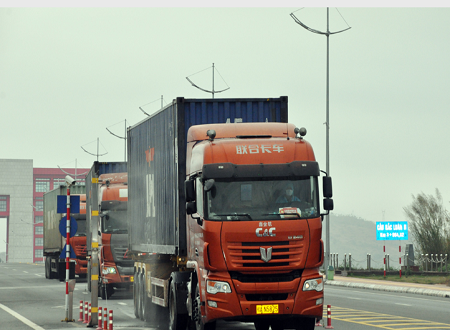 Xe ô tô chở hàng hóa nhập khẩu qua cầu Bắc Luân 2 được phun thuốc khử trùng.