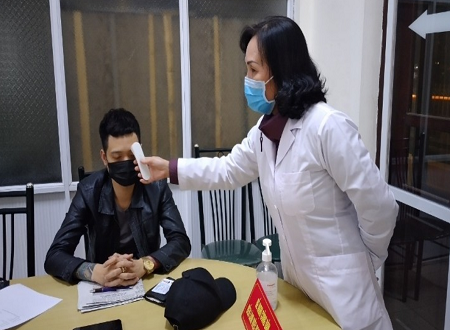 Ngô Văn Chiến được cán bộ y tế đo thân nhiệt trước khi đưa đi cách ly tập trung.