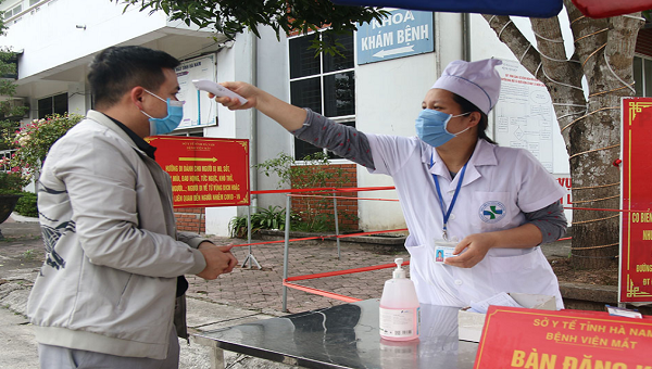 Đo thân nhiệt cho người ra vào Bệnh viện mắt Hà Nam.