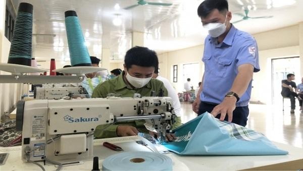 Cán bộ trung tâm cai nghiện ma túy tỉnh Quảng Ninh dạy học nghề may công nghiệp cho học viên đang cai nghiện.