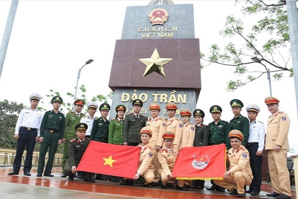 Các đoàn viên thanh niên tham gia lễ thượng cờ tại cột cờ đảo Trần.