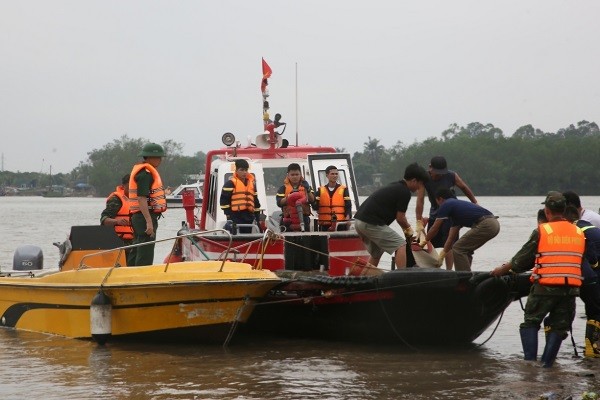 Lực lượng tìm kiếm cứu nạn trục vớt nạn nhân mất tích lên bờ.